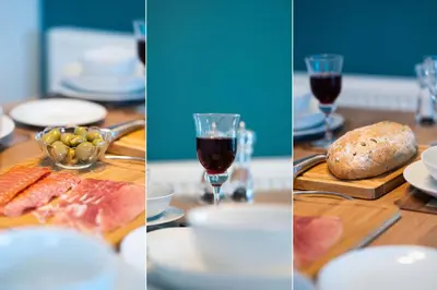 a table with plates of food and glasses of red wine at Trevelyan in St Ives