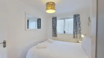 a bedroom with a white bed and a window at B45 Phillippa, Riviere Towans in Hayle