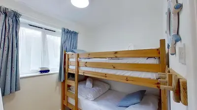 two bunk beds in a room with a window at B45 Phillippa, Riviere Towans in Hayle