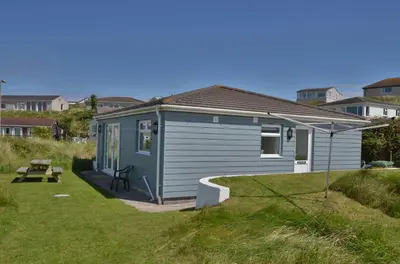 a small blue shed with a bench in a yard at B45 Phillippa, Riviere Towans in Hayle