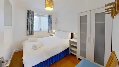 a small bedroom with a white bed and a window at B45 Phillippa, Riviere Towans in Hayle
