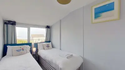 two beds in a small room with a window at B47 Neptune, Riviere Towans in Hayle