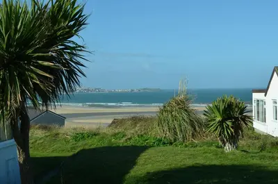 a view of a beach with a house and palm trees at B47 Neptune, Riviere Towans in Hayle
