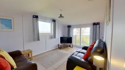 a living room with a couch and a television at B47 Neptune, Riviere Towans in Hayle