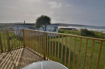 a balcony with a table and a palm tree at B47 Neptune, Riviere Towans in Hayle