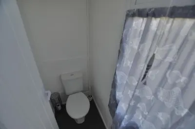 a bathroom with a toilet and a shower curtain at B47 Neptune, Riviere Towans in Hayle