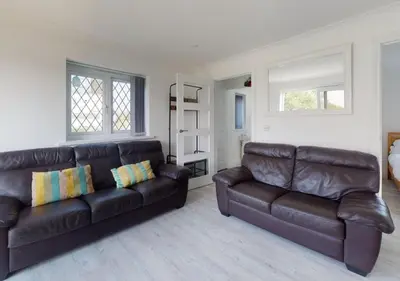 a living room with two brown leather couches at B51 Blue Bay, Riviere Towans in Hayle
