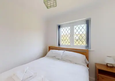 a small bedroom with a bed and a window at B51 Blue Bay, Riviere Towans in Hayle