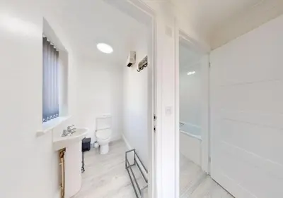 a white bathroom with a sink and a toilet at B51 Blue Bay, Riviere Towans in Hayle