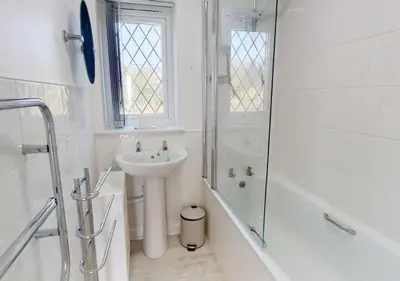 a white bathroom with a sink and a shower at B51 Blue Bay, Riviere Towans in Hayle