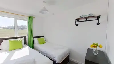 two beds in a room with a window at B50 Kingfisher, Riviere Towans in Hayle