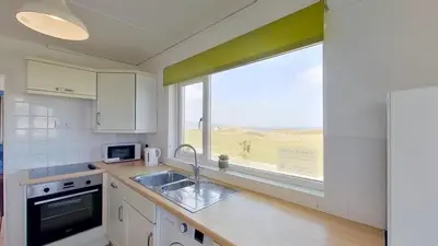 a kitchen with a sink and a large window at B50 Kingfisher, Riviere Towans in Hayle