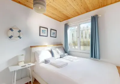 a bedroom with a white bed and a window at C15 Seamore, Riviere Towans in Hayle