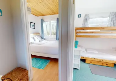 a bedroom with two beds and a bunk bed at C15 Seamore, Riviere Towans in Hayle