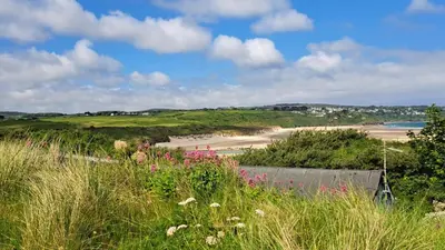 a view of a beach from a field of grass at C15 Seamore, Riviere Towans in Hayle