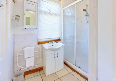 a white bathroom with a sink and a shower at C15 Seamore, Riviere Towans in Hayle