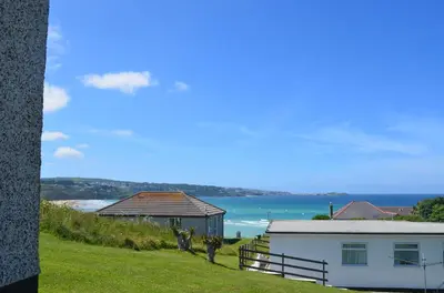 a white house with a view of the ocean at B52 Oyster, Riviere Towans in Hayle