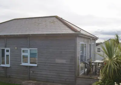 a small house with a patio with a table at C23 Wilmar, Riviere Towans in Hayle