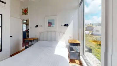 a bedroom with a white bed and a large window at C24 Rosemary, Riviere Towans in Hayle