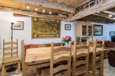 a dining room with a large wooden table and chairs at Lantau Cottage: Historic Elizabethan house very close to the beach in Looe