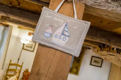 a napkin with a sailboat on it hanging on a wall at Lantau Cottage: Historic Elizabethan house very close to the beach in Looe