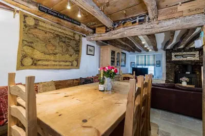 a dining room with a wooden table and chairs at Lantau Cottage: Historic Elizabethan house very close to the beach in Looe