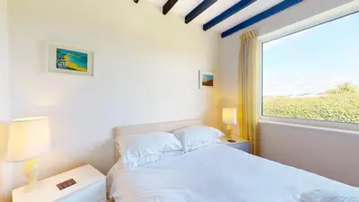 a bedroom with a white bed and a window at C16 Treverbyn, Riviere Towans in Hayle