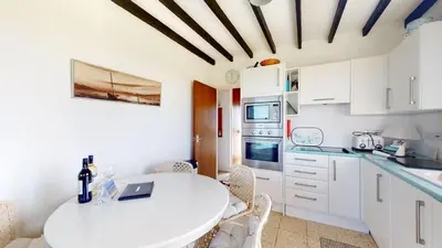 a white kitchen with a white table and chairs at C16 Treverbyn, Riviere Towans in Hayle