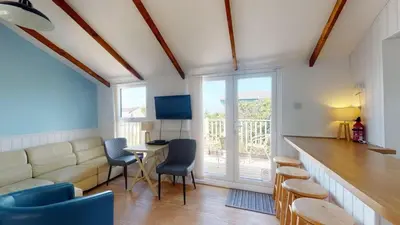 a living room with a couch and a table and chairs at C25 Weir View, Riviere Towans in Hayle
