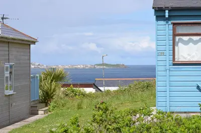 a blue house with a view of the ocean at C25 Weir View, Riviere Towans in Hayle