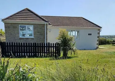 a small house with a fence in a field at C27 Eddleston, Riviere Towans in Hayle