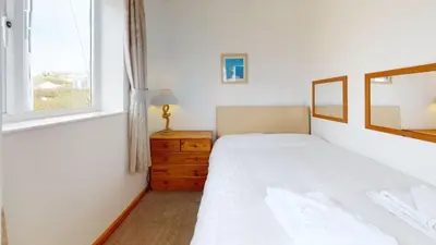 a bedroom with two beds and a window at C27 Eddleston, Riviere Towans in Hayle