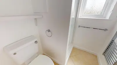a white bathroom with a toilet and a window at C27 Eddleston, Riviere Towans in Hayle
