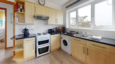 a kitchen with a stove and a dishwasher at C27 Eddleston, Riviere Towans in Hayle