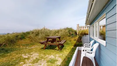 a picnic table and two chairs sitting next to a house at C37 Jupiter, Riviere Towans in Hayle