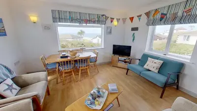 a living room with a couch and a table and a tv at C41 Windmills, Riviere Towans in Hayle