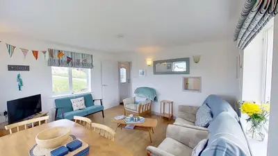 a living room with a couch and a table at C41 Windmills, Riviere Towans in Hayle