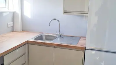 a kitchen with a sink and a refrigerator at Sandy Bay Apartment, St Ives Bay, Hayle in Hayle