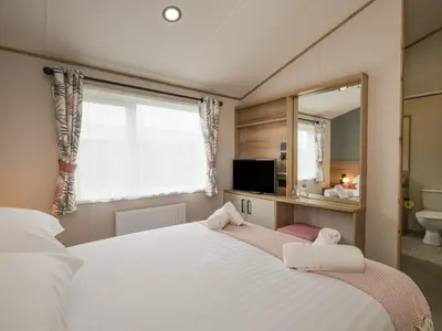 a bedroom with two beds and a mirror at Penmarlam Lodge Retreat 12 in Fowey