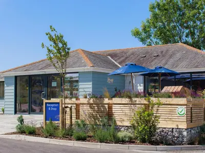 a restaurant with umbrellas in front of a building at Penmarlam Lodge Retreat 12 in Fowey