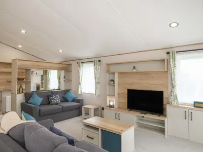 a living room with a couch and a flat screen tv at Penmarlam Lodge Retreat 12 in Fowey