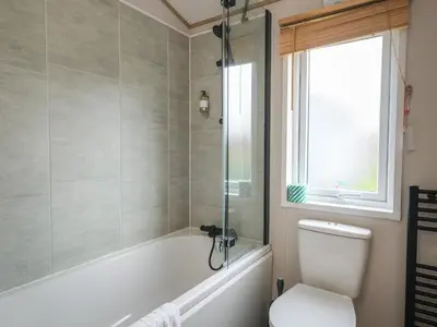 a bathroom with a tub and a toilet and a window at Penmarlam Lodge Retreat 12 in Fowey