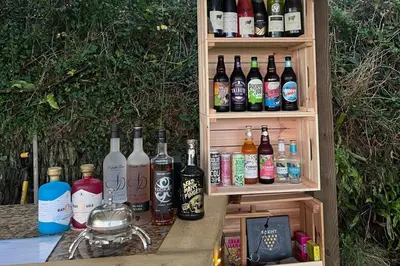 a row of bottles of alcohol sitting on a table at The Pasty - Lydcott Glamping in East Looe
