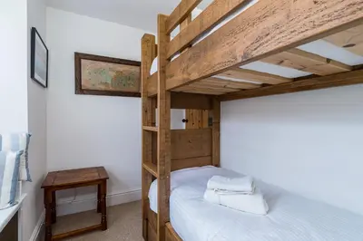 a bedroom with a wooden bunk bed in a room at Jessamine: Restored fisherman's cottage close to Looe's harbour in Looe