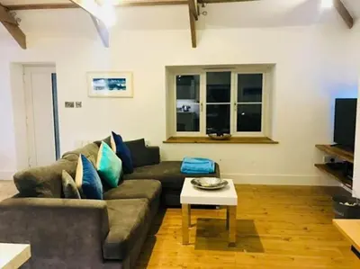 a living room with a couch and a table at UNIQUE CORNISH COTTAGE CONVERSION Central location in Redruth