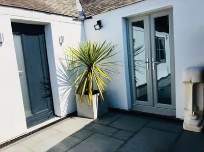 a plant in a pot on the side of a house at UNIQUE CORNISH COTTAGE CONVERSION Central location in Redruth