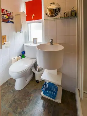 a bathroom with a white toilet and a sink at Birds Nest Cottage Looe in Looe