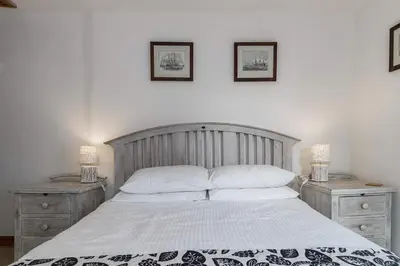 a bedroom with a large bed with two night stands at Historic Osborne House very close to the beach in Looe