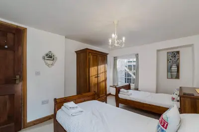 a bedroom with two beds and a window at Historic Osborne House very close to the beach in Looe