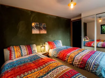 a bedroom with two beds with colorful blankets at Chy Glynn. Luxury lodge with hot tub and views. in St. Agnes